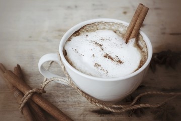 hot cappuccino with spices cinnamon sticks and star anise.