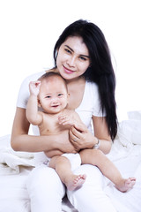 Attractive young mother and her baby isolated