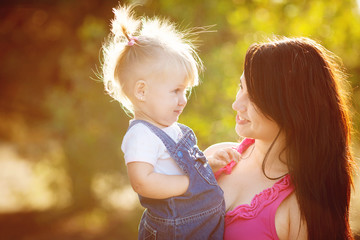 Fototapeta premium Young mother with child outside on a summer day