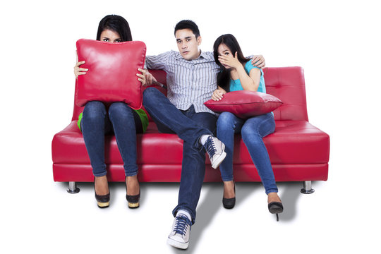 Three young people watching TV