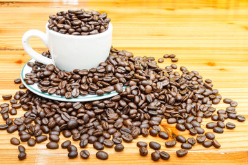 coffee beans on cup and wooden table