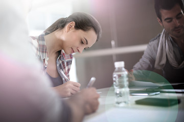 Students in class writing on notebooks