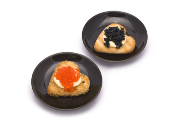 Two Heart-Shaped Toasts with Red and Black Caviar on White Sauce