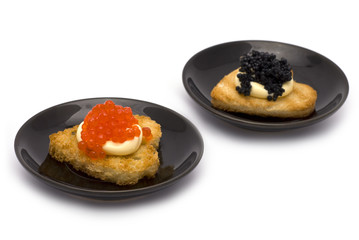 Two Heart-Shaped Toasts with Red and Black Caviar on White Sauce