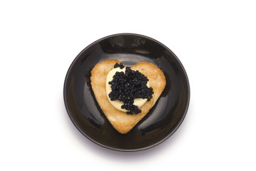 Small Plate with Heart-Shaped Toast with Caviar on White Sauce i