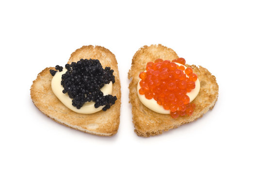 Two Heart-Shaped Toasts with Red and Black Caviar on White Sauce