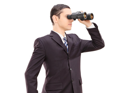 Young businessman looking through binocular