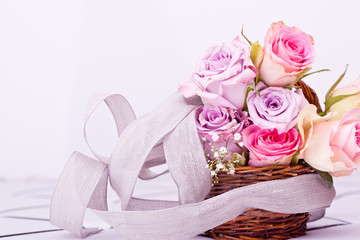 pink roses in brown basket with grey bow
