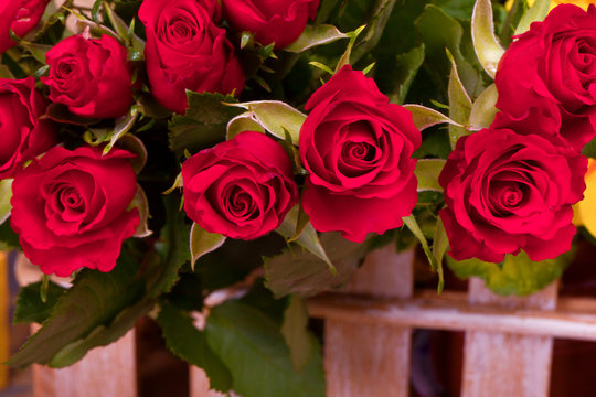 many red roses in brown basket