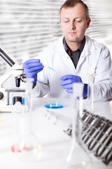 scientist working in the lab , examines a with liquid