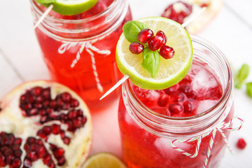 Two glasses with red pomgranate juice, lime and mint.