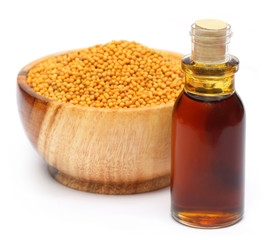 Fresh golden mustard on a wooden pot with oil