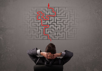 Business man looking at a maze and the way out