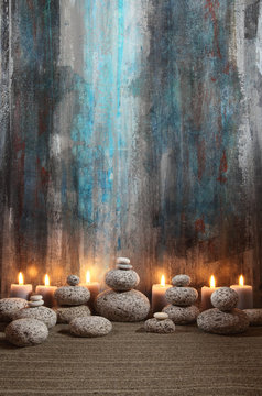 Runde Steine und Kerzen vor abstraktem Gemälde
