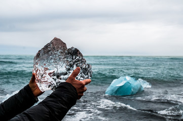 Hands holding a block of pristine glacier ice