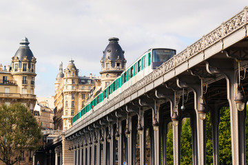 Metro train runs high between buildings, Paris, France. Cityscape in summer.