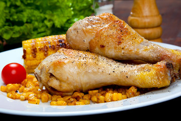 chicken thigh with a boundary of corn cob and salad