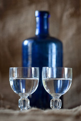 Vodka or plum brandy on a old rag sack background