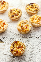 Homemade tart with dried fruits and fresh apples on white wooden