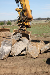 Fototapeta premium Digger Collecting Rocks