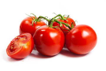 three fresh tomatoes with green leaves isolated on white backgro