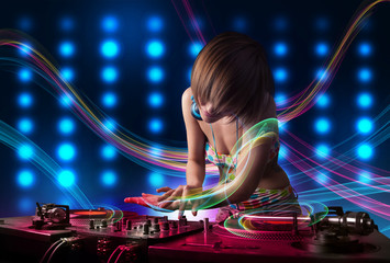 Fototapeta na wymiar Young Dj girl mixing records with colorful lights