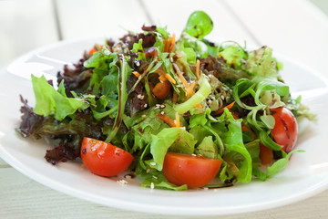Fresh vegetable salad with arugula on white plate