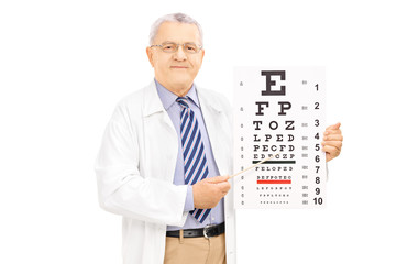 Fototapeta na wymiar Middle aged male optician holding eyesight test and pointing wit