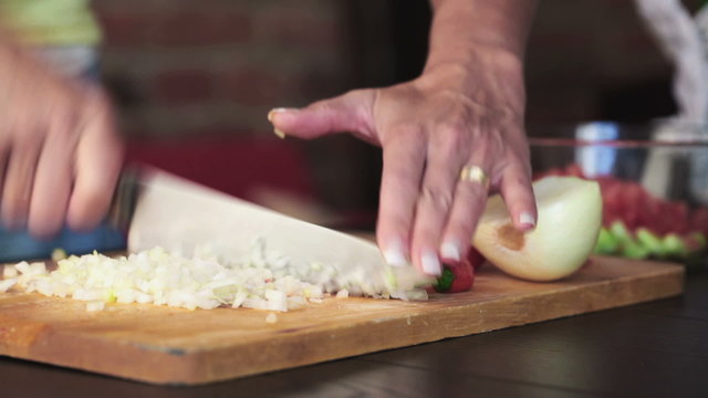 Female hands with knife chopping fresh onion