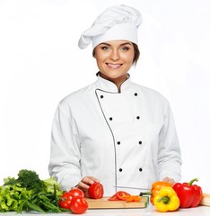 Beautiful young woman cook cutting fresh tomatoes