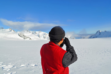 Fototapeta na wymiar Photographer shooting at top of ice mountain