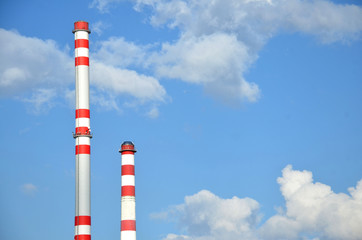 Two factory chimneys with sky in the background