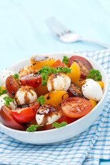 bowl of salad with mozzarella, balsamic and colorful cherries
