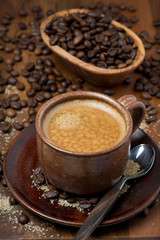 espresso cup, sugar and coffee beans on wooden table