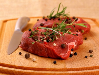 Two juicy beef steak with spices and steel knife