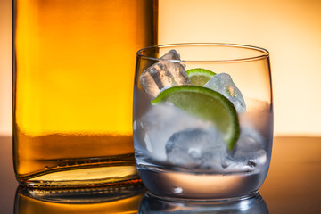 Glass and bottle of hard liquor like scotch, bourbon, whiskey or