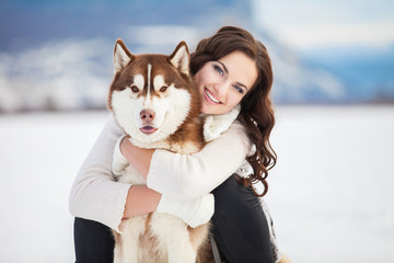 Girl embracing cute siberian husky in winter park