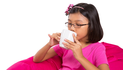 Young girl drinking from a white mug background