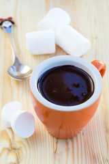 Cup of chocolate with marshmallows on wooden surface