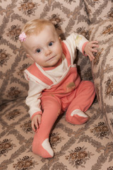 Fototapeta premium portrait of toddler girl sitting on armchair