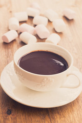 Cup of chocolate with marshmallows on wooden table
