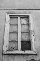 window with broken pane and flaky peeling paint