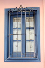 blue painted wood window on a pink wall