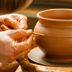 hands of a potter, creating an earthen jar