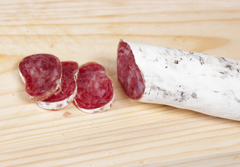 salami cut with a knife on a cutting board