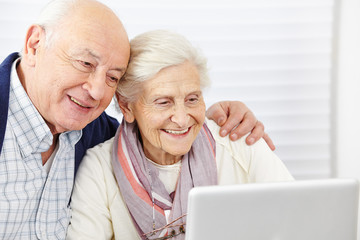 Paar Senioren schaut auf Computer