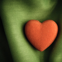 Valentine's day background. Red heart on green folds cloth