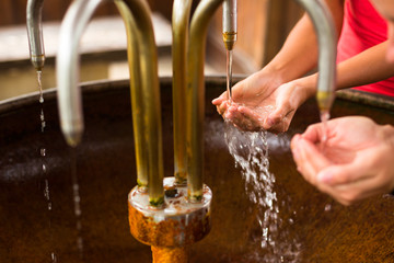 People filling up their hands with healthy mineral water