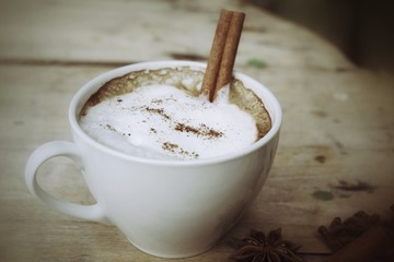 hot cappuccino with spices cinnamon sticks and star anise.