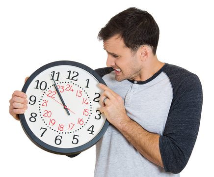 Young man with wall clock running out of time 